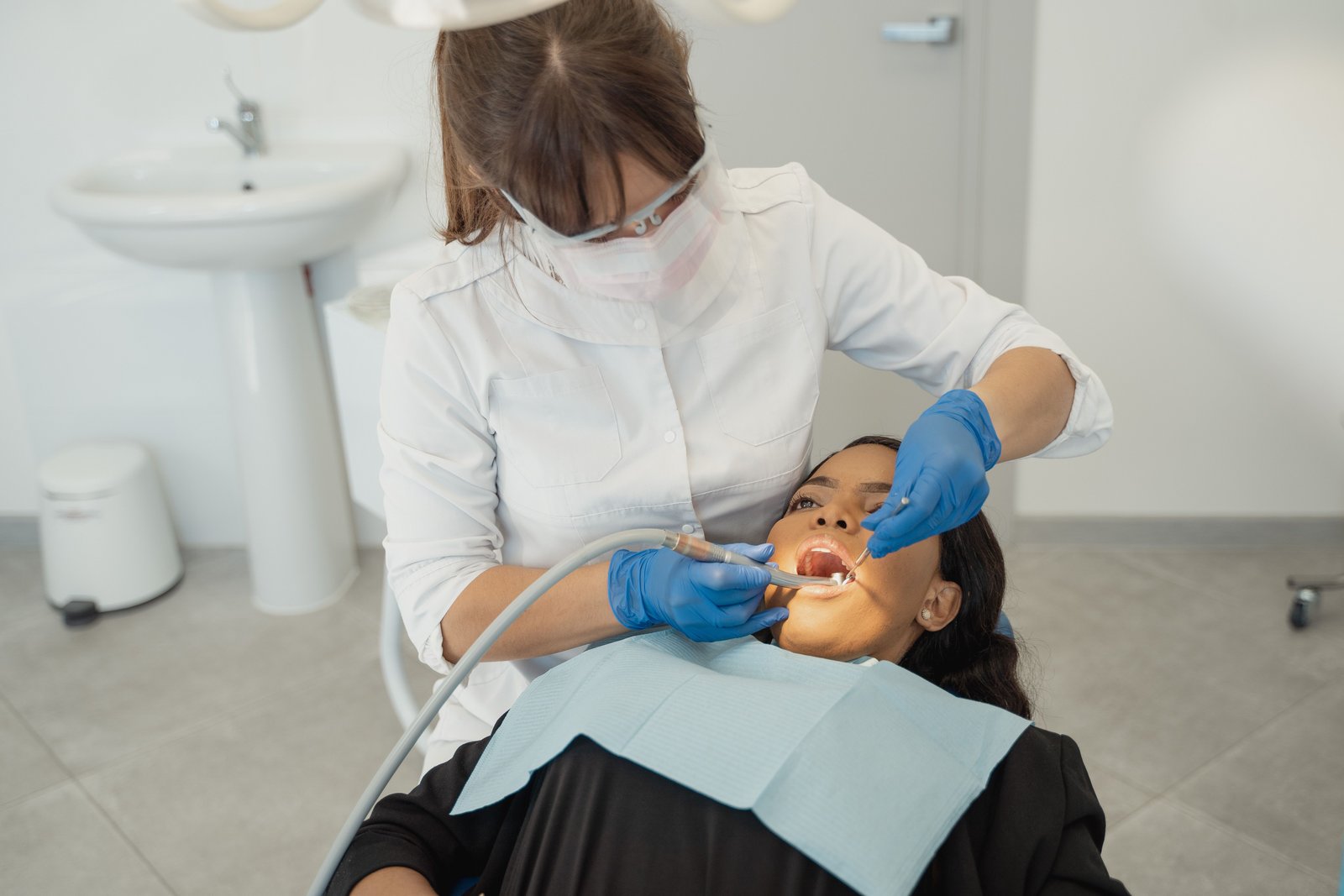 A dentist working on a patient in a bright treatment room